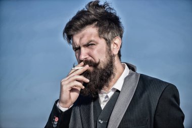 Sigara içmek için mola. Sakallı adam sigara içiyorum. duman. Bıyıklı acımasız beyaz hippi. Gelecekteki başarısı. Erkek resmi moda. İş adamı gökyüzüne karşı. Olgun hipster sakallı