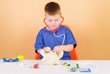 Sağlık. Çocuk küçük doktor meşgul tıbbi araçlar ile masa. Tıbbi muayene. Tıp kavramı. Oyuncak ayı için tıbbi prosedürler. Tıp eğitimi. Çocuk sevimli çocuk gelecek doktor kariyer