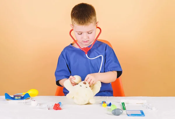 Health care. Kid little doctor busy sit table with medical tools. Medical examination. Medicine concept. Medical procedures for teddy bear. Medical education. Boy cute child future doctor career — Stock Photo, Image