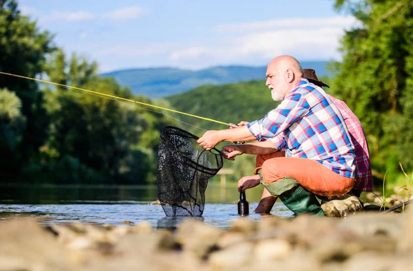 Partager ses secrets. Pêcheur expérimenté montrer des conseils à son fils. Belle soirée bord de rivière. Les hommes pêchent le poisson au bord de la rivière. Enseigner la pêche. Transfert des connaissances. Les amis passent du bon temps au bord de la rivière — Photo