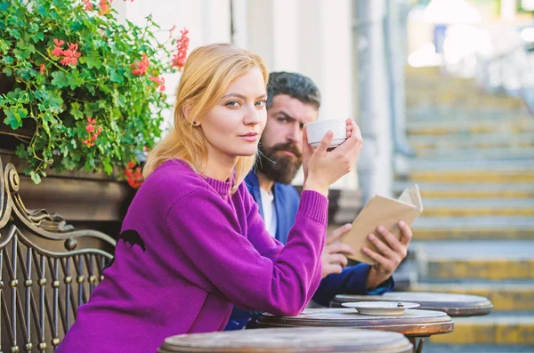 Morning coffee. Couple in love on romantic date. First meet of girl and mature man. Brutal hipster and girl drink coffee. woman and man with beard relax in cafe. reading and drinking coffee in care