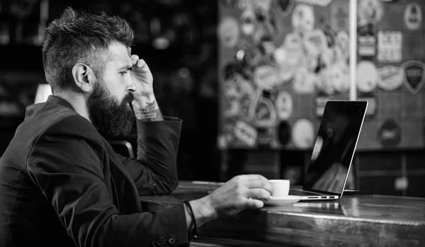 Hipster frilanser jobber med blogg notatbok. Surfet på internett. Frilanser. Mannen med skjegget forretningsmann sitter på puben med laptop og kaffe. Direktøren jobber online mens han nyter kaffe. Nettbasert arbeid – stockfoto