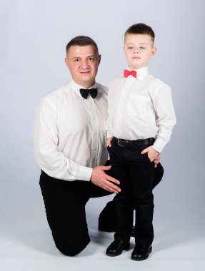 Papyonlu baba ve çocuk. Centilmen yetiştirilme tarzı. Resmi bir olay. Küçük oğul soylu bir adam babaları örnek takip. Centilmen yetiştirilme tarzı. Baba ve oğul resmi kıyafet kıyafeti. Büyüyün beyefendi