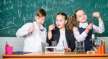 Takım çalışması konsepti. Renkli sıvı maddeler ile test tüpleri. Sıvı durumların incelenmesi. Grup okulu öğrencileri kimyasal sıvılar üzerinde çalışıyor. Kızlar ve erkek öğrenci sıvılar ile deneme yapmak. Sonucu kontrol edin