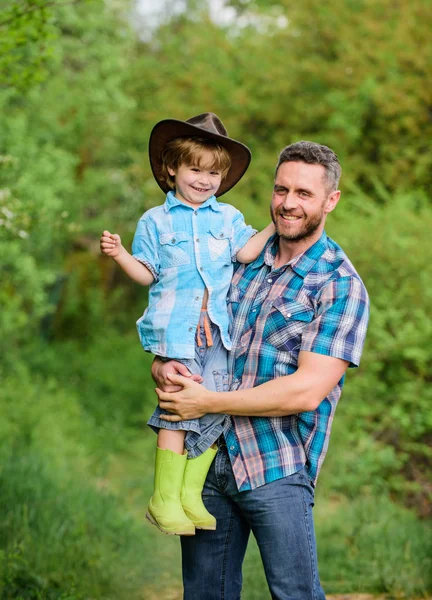 Little boy and father in nature background. Spirit of adventures. Child having fun cowboy dad. Farm family. Holidays at parents farm. Growing cute cowboy. Weekend at farm. Little helper in garden — Stock Photo, Image