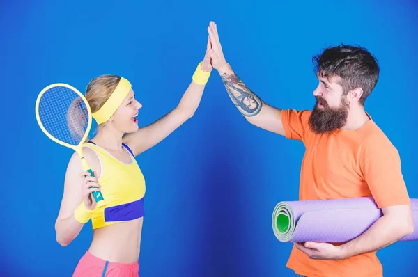 You may be strong but we are stronger. Sport equipment. Sporty couple training with fitness mat tennis racket. Happy woman and bearded man workout in gym. Athletic Success. Strong muscles and body