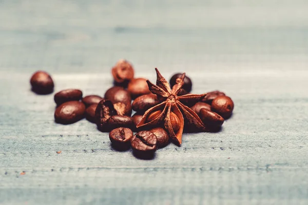 Coffee shop or store. Fresh roasted coffee close up. Pile beans on blue wooden background. Coffee for inspiration and energy charge. Texture and background concept. Degree of roasting coffee beans
