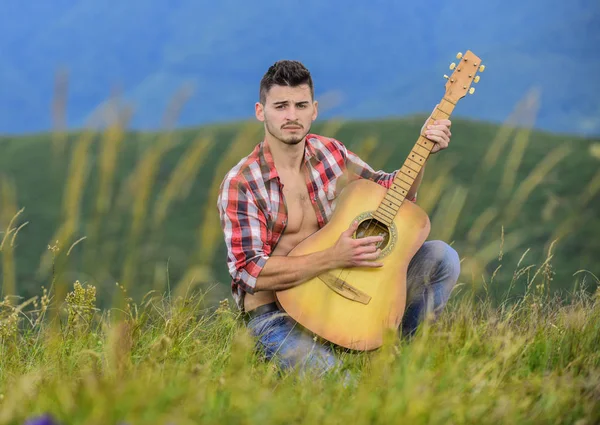 Φέρτε τη μουσική στη ζωή. σέξι άνθρωπος με κιθάρα σε καρό πουκάμισο. χίπικο στυλ. Δυτική κατασκήνωση και πεζοπορία. ευτυχισμένοι και ελεύθεροι. καουμπόης με ακουστική κιθαρίστα. μουσικό τραγούδι κάντρι — Φωτογραφία Αρχείου