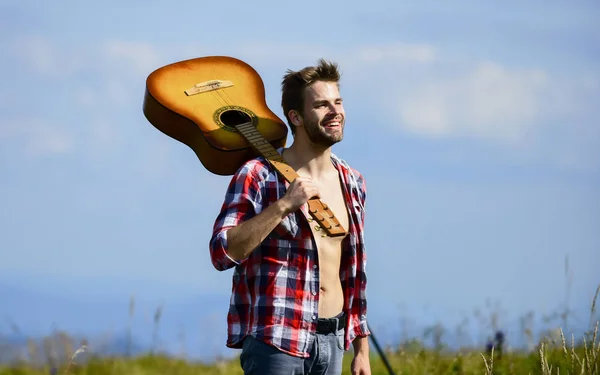 Músico à procura de inspiração. Conceito de luxúria. Inspirando a natureza. Férias. Vagabundo sonhador. Humor tranquilo. Um tipo com guitarra contempla a natureza. À procura de musa. Unidos com a natureza — Fotografia de Stock