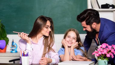 Anne ve baba öğretmenler öğrenme ile çocuk yardımcı olur. Akıllı bir aile. Kıza ders veriyor. Öğrenmek için uygun koşullar. İyi bir öğrenme ortamı. Öğrenciler, kendilerini desteklenmiş ve saygı duyulan hissetmeli