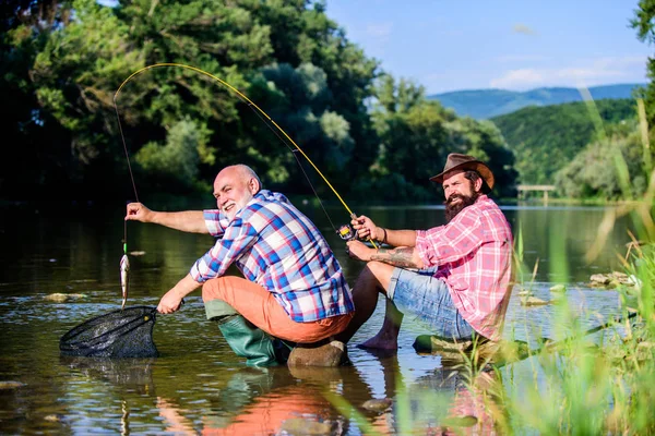 Poaching crime and fishing license. Black market caviar. Poachers fishing. Trap for fish. Men sit at riverside with fishing equipment. Illegal hunting caviar. Extracts eggs from sturgeon caught river — Stock Photo, Image