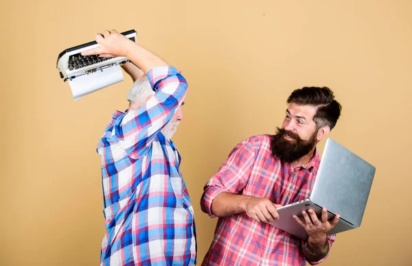 Crush test. retro typewriter vs laptop. New technology. father and son. family generation. youth vs old age. business approach. technology battle. Modern life. two bearded men. Vintage typewriter — Stock Photo, Image