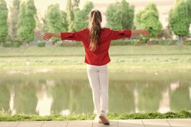 Saç stilim kendi adına konuşuyor. Nehir kenarında rahat giyim uzun saç modeli ile küçük kız. At kuyruğu saç modeli açık giyiyor sevimli küçük çocuk. Yaz için en iyi saç modeli ile Sevimli çocuk
