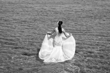 Gelin beyaz gelinlik deniz suyunda standı. Islı gelinlik sıcak güneşli bir gün. Gelin mutlu yaz tatili okyanus arka plan keyfini çıkarın. Deniz tatil beldesinde balayı. Yurt dışında düğün. Düğün töreni deniz kıyısı