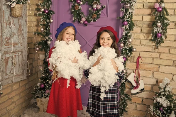 Todo lo que brilla es nieve. Los niños felices celebran la Navidad y el año nuevo. Diversión invernal. Juegos infantiles en vacaciones de invierno. Niños pequeños con nieve artificial. Niñas pequeñas con decoración de Navidad — Foto de Stock