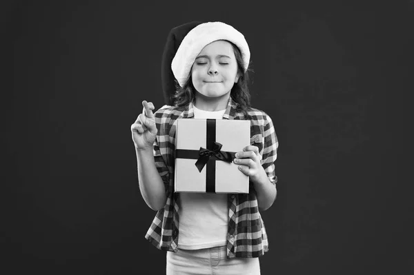 Felices fiestas de invierno. Niña pequeña. Regalo para Navidad. Infancia. Fiesta de año nuevo. Chico Santa Claus. Compras de Navidad. Niña con sombrero rojo de santa. Pruébalo. Sé positivo. —  Fotos de Stock