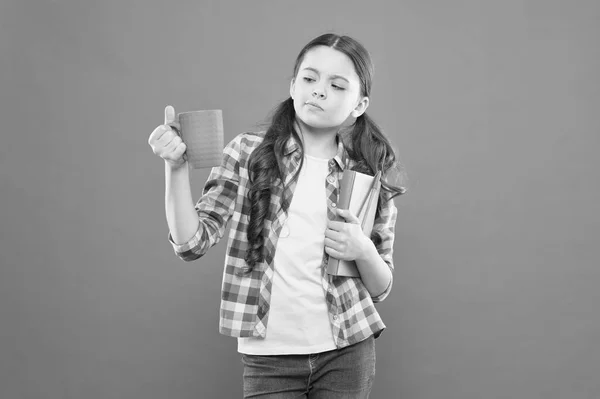 Profitez de passer du temps chez vous. Chocolat chaud et bon livre combinaison parfaite pour une soirée confortable. Je lis la liste des seaux. Passez du bon temps avec votre livre préféré. Une fille tient une tasse de thé et un livre. Littérature pour enfants — Photo