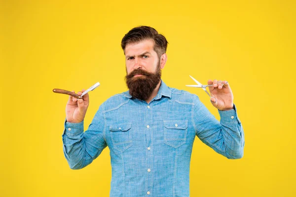 Barbería oferta gama de paquetes para el novio. El barbudo trabaja en la peluquería. Hipster sostiene herramientas de peluquero de fondo amarillo. Concepto de barbería. Formado y peinado de barba en barbería — Foto de Stock