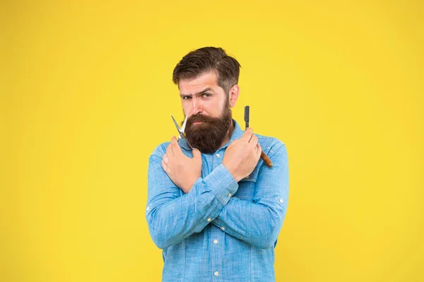 Fazer a barba com uma lâmina a sério parece fixe. Homem barbudo preparar ferramentas de barbear fundo amarelo. Hipster segurar barbear navalha e tesoura. Barbear profissional do mestre barbeiro. Barbearia de barbear — Fotografia de Stock