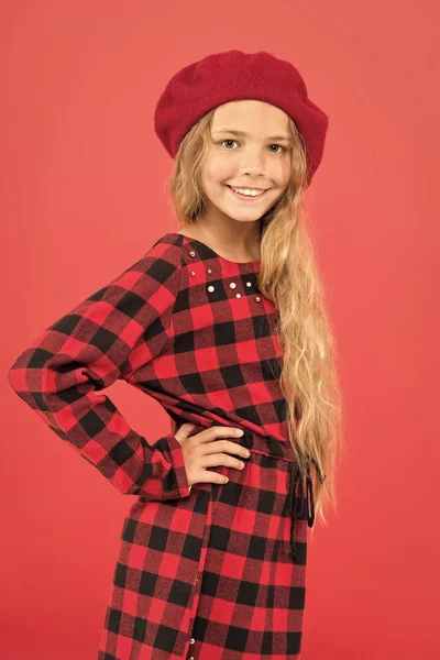 How to wear french beret. Beret style inspiration. How to wear beret like fashion girl. Fashionable beret accessory for female. Kid little cute girl with long hair posing in hat red background
