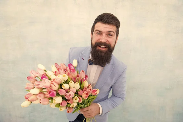 De bonne humeur. marié de mariée à la fête de mariage. homme barbu en nœud papillon avec des fleurs de tulipe. rendez-vous amoureux avec des fleurs. Joyeux anniversaire. bouquet de printemps. 8 de mars. Journée des femmes. Entreprises formelles matures — Photo