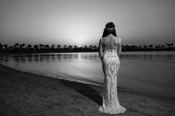 Brud vit bröllopsklänning stå på sandstrand. Brudklänning. Bride Happy njuta Sunset Ocean bakgrund. Kvällens ceremoni. Smekmånad på Sea Resort. Bröllop utomlands. Bröllopsceremonin Seashore — Stockfoto