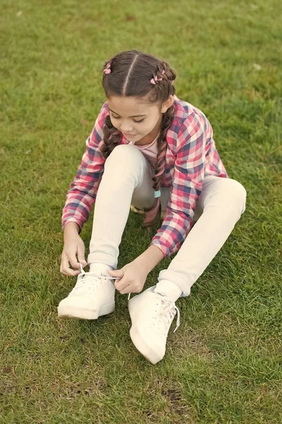 enjoying leisure time. small girl relax on green grass. Parks and outdoor. Spring nature. Summer picnic. Small school girl with trendy hair. happy childhood. total relaxation. leisure activities