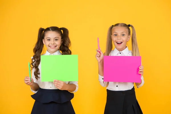 Tenho uma ideia. Pequenos meninos bonitos sorrindo de ideia de gênio. Meninas felizes segurando folhas de papel para escrever ideia no fundo amarelo. Crianças pequenas com papel vazio para ideia criativa, espaço de cópia — Fotografia de Stock