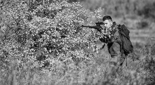 Бородатый серьезный охотник проводит досуг охоты. Охотник держит винтовку. Мужчина носит камуфляжную одежду на природе. Разрешение на охоту. Охота жестокое мужское хобби. Оборудование для охоты для профессионалов — стоковое фото