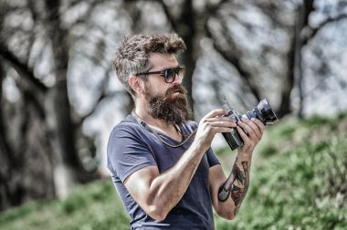 Elle ayarlar. Fotoğrafçı klasik fotoğraf makinesini tutar. Modern blogcu. Sakallı ve bıyıklı bir fotoğrafçı. Adam fotoğraf çekiyor. İçerik yaratan. Sakallı hippi fotoğrafçı. Yaşlı ama hala iyi.