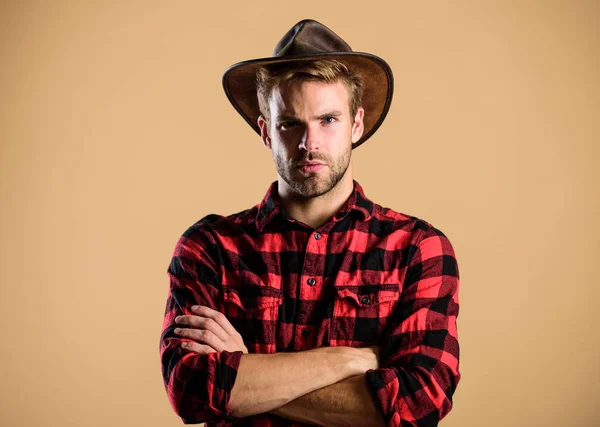 Cowboy americano. Padrão de beleza. Exemplo de verdadeira masculinidade. Um cowboy a usar chapéu. A vida ocidental. Homem unshaven cowboy bege fundo. Um tipo sem barba de chapéu de cowboy. Bonito macho barbudo — Fotografia de Stock