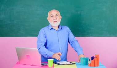şef editör makale ile bakmak. Okula geri dön. Eğitim kavramı. Kahve fincanı olan olgun öğretmen adam. sınıfta öğretmen. Not lar hazırlıyor. okul ders molası. dizüstü bilgisayar ve bilgisayar ile üst düzey adam