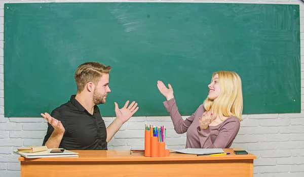 Gymnasialausbildung. Paar, das im Klassenzimmer lernt. Mann und Frau zurück in die Schule. hübsche Lehrerin und gut aussehende Schulleiterin. Universitäts- oder College-Studenten glücklich lächelnd am Schreibtisch. Wir haben es geschafft — Stockfoto