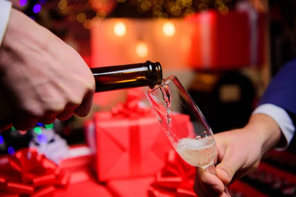 All'ultimo minuto prima del nuovo anno. Bevi champagne o spumante. Festeggia il nuovo anno con lo champagne. Mani versando champagne in eleganti decorazioni natalizie in vetro sfondo. Il concetto di salute — Foto Stock