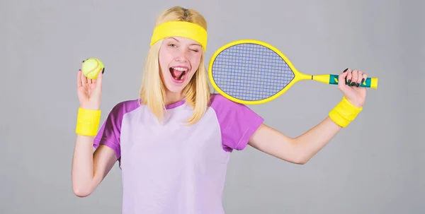 Спорт для підтримки здоров'я. Активне дозвілля та хобі. Спортсмен тримає тенісну ракетку в руці на сірому фоні. Тенісні види спорту та розваги. Концепція тенісного клубу. Дівчина чарівна блондинка грає в теніс — стокове фото