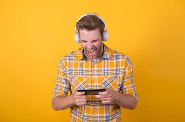 Oyuna dahil olmuş. Müzik aboneliği al. Adam memnun müzik dinliyor modern kulaklıklar ve akıllı telefon. Dinlemeyi hak eden en iyi müzik uygulamaları. Guy modern kullanıcı mobil uygulaması. Taze müzik konsepti