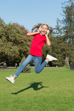Mükemmel yüksek sesli ses. Hiç bitmeyen neşe. Müzik dinleyen kız, modern alet. Çocuk, kablosuz kulaklıkla dans edip zıplamaktan memnun. Stereo kulaklık. Çocuk modern teknolojiyi kullanıyor. Modern çocuk