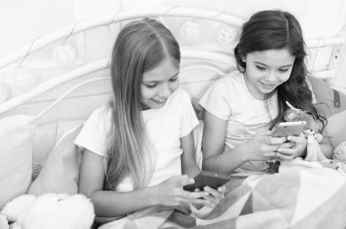 Hepimizin mutlu Noeller. Yeni Yılınız Kutlu Olsun. Cep telefonu ile mutlu küçük çocuklar. Telefonla manifatura Noel ve yeni yıl tebrik. Küçük kızlar smartphone yatakta kullanın.