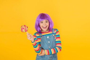 Modern çocukluk. Yapay saç stili olan çocuk lolipop yiyor. Anime toplantısı. Güzel bir hayat. Anime kostüm partisi konsepti. Mutlu küçük kız. Anime hayranı. Canlı karakter fantastik temaları