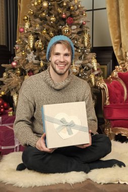 Hediye kutusu oturup Noel ağaç adam gülümseyerek