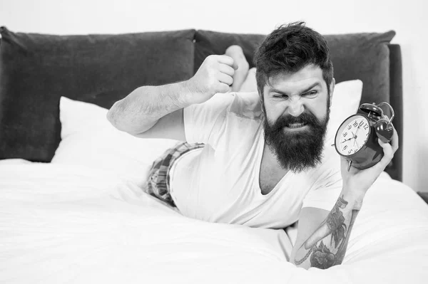 Feeling stressed. Too much noise. angry bearded man crush alarm clock. brutal aggressive man in bedroom. mature male with beard on bed. asleep and awake. energy and tiredness. time management — Stock Photo, Image