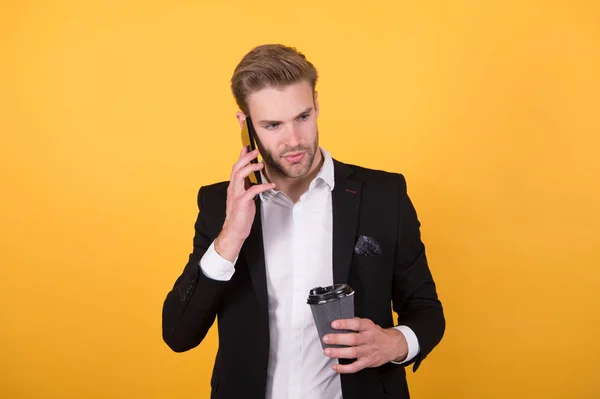 Reporting news. Man drink coffee speak phone yellow background. Drink coffee. Reasons entrepreneurs drink coffee. Coffee break concept. Relax and pleasure. Concentrated on listening information