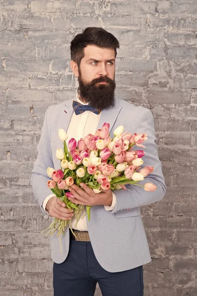 Wir nehmen Blumen persönlich. Frühlingsgeschenk. Bärtiger Hipster mit Blumen. Liebe. Feiertag. Frauentag. 8. März. Bärtiger Mann mit Tulpenfrühlingsstrauß. Frühlingszeit. Frühling genießen — Stockfoto