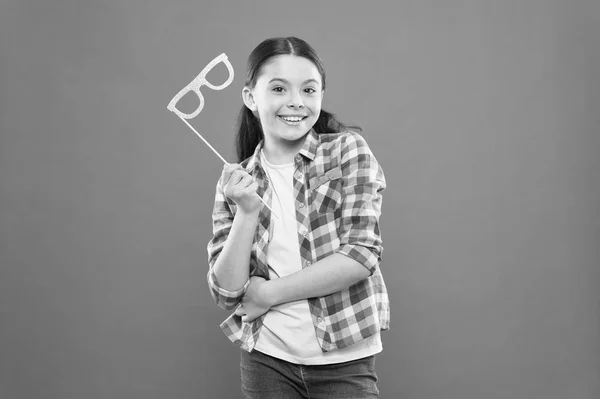 My party photo booth. Cheerful party girl on orange background. Adorable little child holding party props on stick. Cute small kid smiling with happy party look — Stock Photo, Image