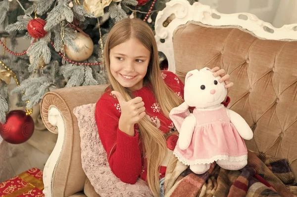 I like it. Small child happy smiling with present. Little girl with cute bunny at Christmas tree. Small girl hold rabbit toy. Little child show thumbs up to soft toy. Best Christmas toy — Stock Photo, Image