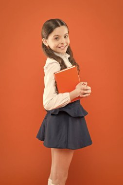 Çocukluk anıları. turuncu arka plan üzerine notlar yazma kız öğrenci. notlar yapmak için günlük. bilgi formu kitap almak. Okula geri dön. Edebiyat dersi alan kız öğrenci. okul üniforması küçük kız