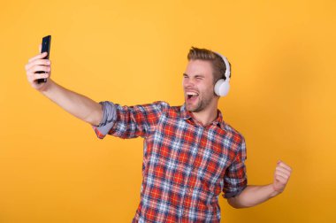 Canlı konser çevrimiçi. Dinlemeyi hak eden en iyi müzik uygulamaları. Guy kullanıcı mobil uygulaması. Müzik aboneliği al. Adam memnun müzik dinliyor modern kulaklıklar ve akıllı telefon. Taze müzik konsepti