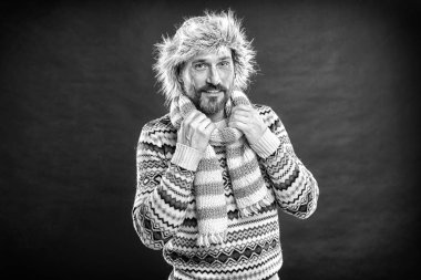 Bir kış topluluğu onu soğuktan korur. Sakallı adam şapka ve eşarp ile kazak accessorizing. Soğuk hava tarzında yaşlı moda modeli. İnsan için kışlık gardırop. Kış için giyinme, siyah beyaz