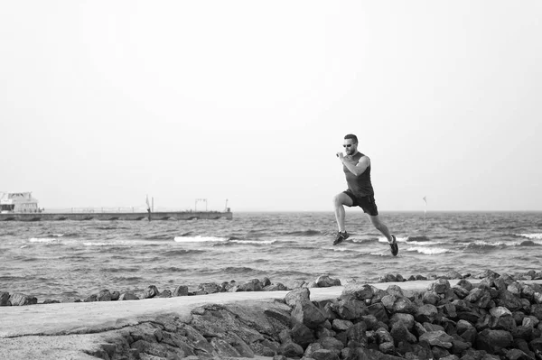 athlete runner along sea coast. running to success. summer vacation. copy space. speed concept. goal and future. people and nature. man runner focused on achievement. life as marathon or sprint