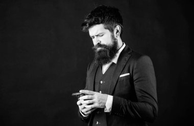 Modern teknolojiler. İşadamı bakımlı adam akıllı telefon tutun. Adam resmi takım akıllı telefon sosyal ağlar kullanın. Adam sörf internet akıllı telefon siyah arka plan. Online hizmet ve uygulama